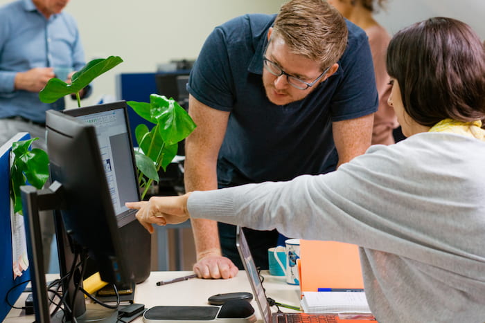 Image of woman pointing at a computer screen in Axis Chester office